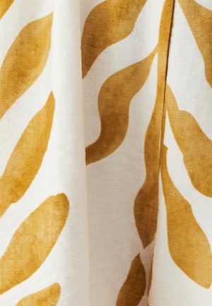 Puuvillane kangas, millel on valge taust ja silmapaistvad vertikaalsed sinepikollased lehekujulised mustrid, esitades pehmet tekstuuri.