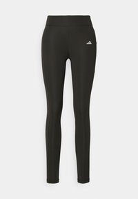 Leggings atléticos negros hechos de material elástico, con una cintura alta, ajuste slim y un pequeño logo blanco en la parte superior izquierda.