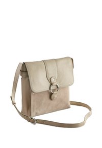 Geantă bej crossbody cu clapetă din piele și corp din piele întoarsă, închidere cu inel argintiu, curea reglabilă și textură fină.