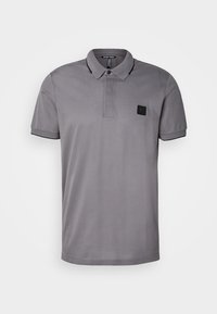 Polo gris en tissu lisse, avec un col classique, des manches courtes et un petit écusson logo noir sur la poitrine.