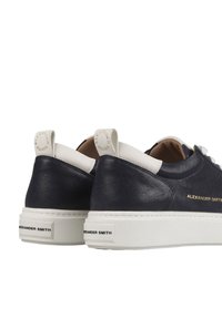 Navyblaue Leder-Sneaker mit weißen Akzenten, ausgestattet mit einer strukturierten Oberfläche, Logodetails und einer Plattformsohle.