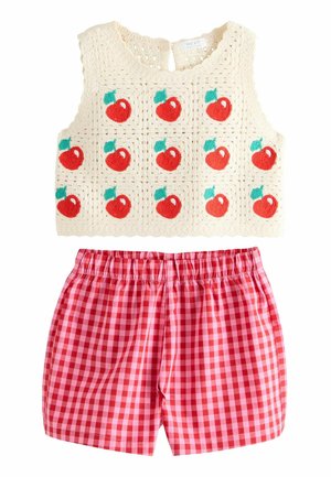 Ärmelloses Top aus cremefarbenem Häkelstoff mit roten Apfelmustern, kombiniert mit rosa und roten Vichy-karierten Shorts mit elastischem Bund.