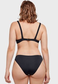 Set di bikini nero con un design semplice, spalline regolabili, chiusura sul retro e parte inferiore a vita alta. Texture liscia in tutto il capo.