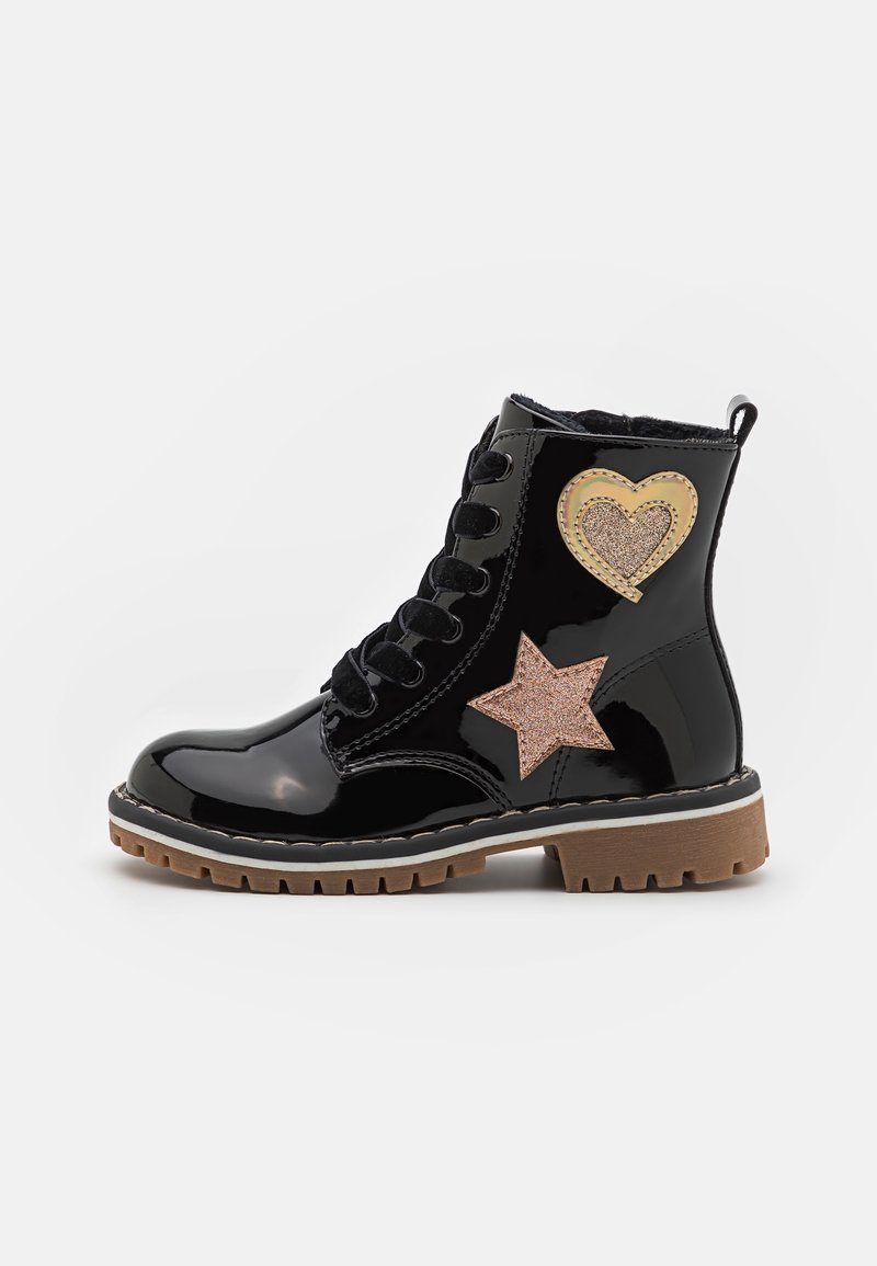Botines de cuero negro patentado con diseño de cordones, con un aplique de corazón dorado y estrella rosa, y una suela marrón resistente.