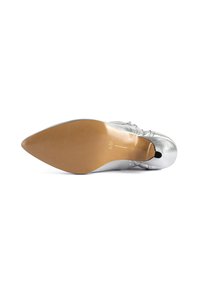 Soletta di scarpa metallica argentata con punta a forma appuntita. Finitura liscia con tacco in gomma marrone e marchio in rilievo vicino alla punta.