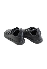 Zapatos de cuero negro con un acabado suave, que cuentan con una punta redondeada y dos tiras de velcro en la parte superior. Suela de goma flexible para mayor comodidad.