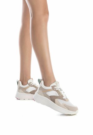 Sneaker leggere con una combinazione di colori beige, bianco e verde. Presentano pannelli in rete e testurizzati, una suola ammortizzata e un design con lacci.