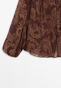 Blusa color marsala con un motivo paisley dorato. Tessuto leggero e semitrasparente con un aspetto fluido e maniche a palloncino arricciate.