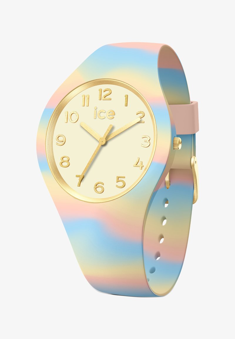 Montre en silicone multicolore avec un cadran doré, un fond crème et de grands marqueurs numériques ; elle possède un bracelet dégradé pastel et de simples aiguilles dorées.