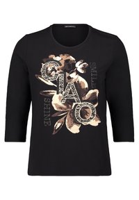 Zwarte longsleeve shirt met beige bloemenprint en grote gestifte letters die "CIAO" spellen, met de woorden "SWEET TIME" op de voorkant.