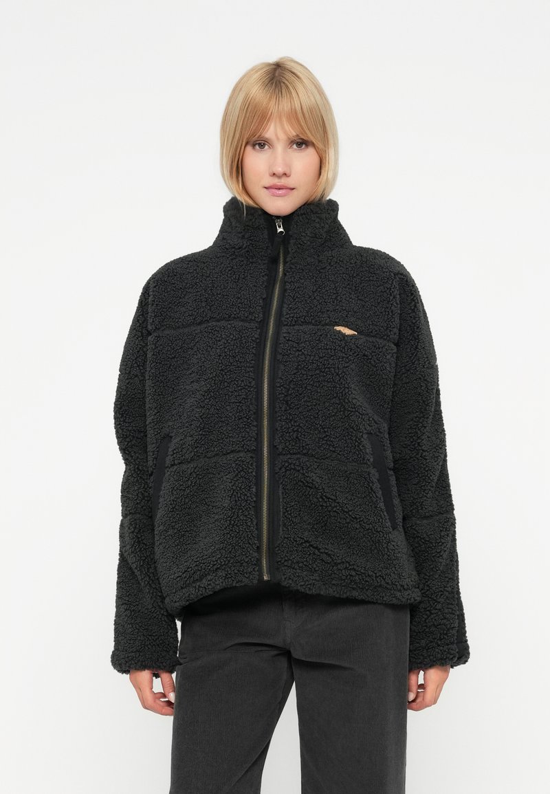 Schwarze Fleecejacke mit hohem Kragen, Reißverschlussfront und Seitentaschen. Sie verfügt über ein strukturiertes Muster und elastische Bündchen.