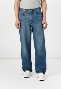 Light blue denim jeans with a relaxed fit, straight leg design, and subtle fading. Features five pockets and silver hardware detailing.