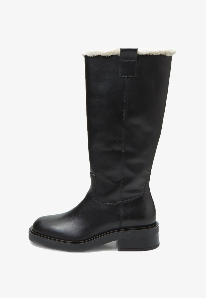 Stivale nero in pelle al ginocchio con una soffice falda in pelliccia sintetica bianca, punta arrotondata e tacco a blocco. Texture liscia con dettagli di cucitura minimi.