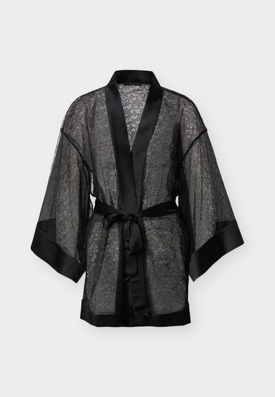 Bata de encaje negro con ribete de satén, mangas anchas y cinturón de satén atado a la cintura, exhibida sobre un fondo blanco.