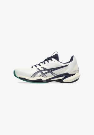 White and navy athletic shoe, featuring a breathable mesh upper, patterned texture, and green accents on the sole. Designed for performance.