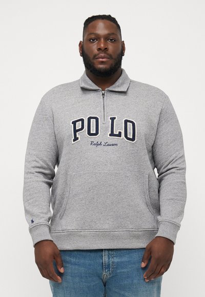 Harmaa fleece-huppari, jossa on vetoketjullinen kaulus. Rinnassa on brodeeratut tekstit "POLO" ja "Ralph Lauren", ja siinä on kengurutasku.