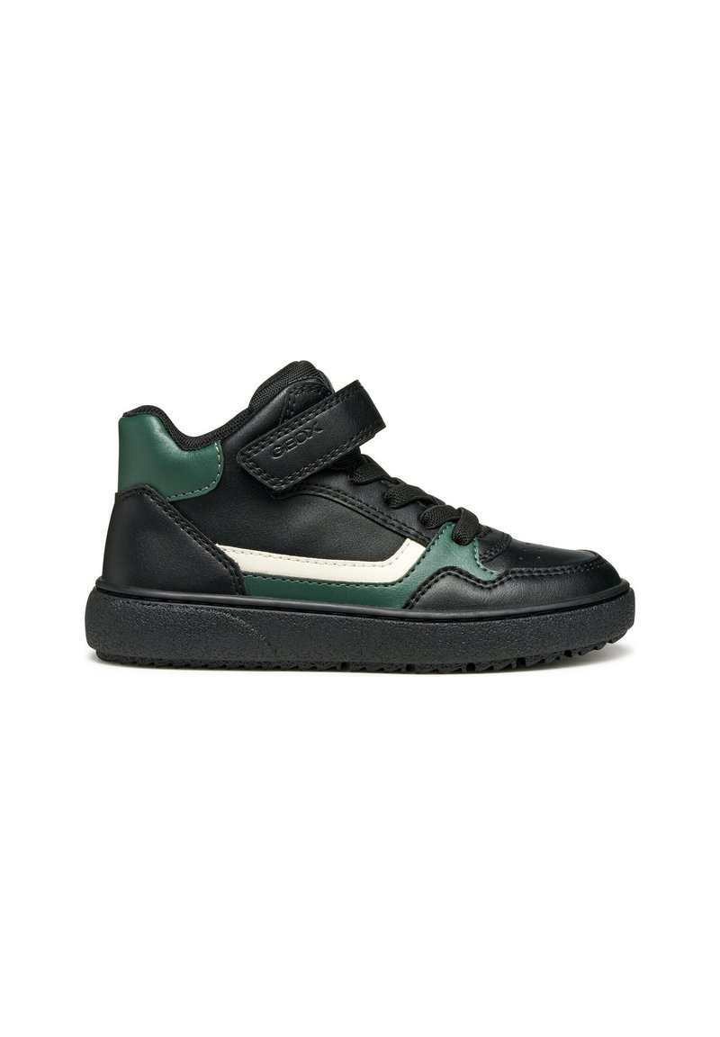 Baskets montantes noires avec des accents verts et blancs, fabriquées en cuir, dotées d'une sangle en Velcro et d'une semelle en caoutchouc texturé.