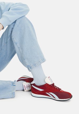 Czerwone i niebieskie buty sportowe z cholewką z zamszu i siateczki, z białym logo na pięcie i teksturowaną gumową podeszwą.