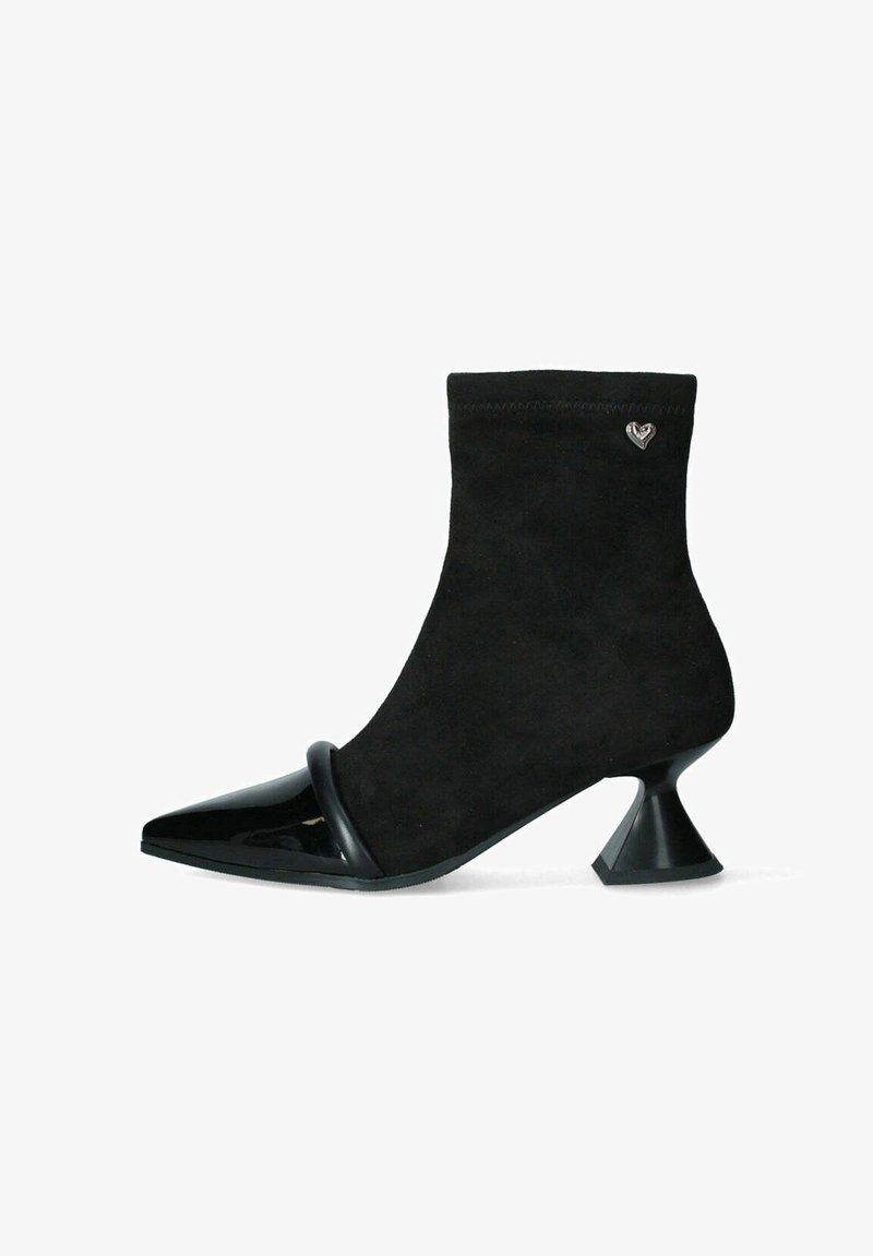 Stivale ankle nero con tomaia in suede, punta affusolata, rifiniture in pelle verniciata lucida e una particolare forma del tacco a corolla. Presenta un accento a forma di cuore.