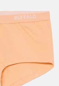 Őszibarack színű pamut női rövidnadrág, puha, rugalmas derékkal, fehér "BUFFALO" felirattal. Sima textúra és varrás nélküli élek.