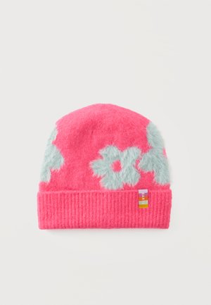 Bonnet tricoté rose vif avec des motifs floraux flous bleu clair et une petite étiquette en tissu multicolore sur le revers.