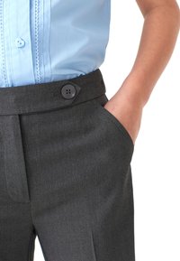 Pantaloni gri cu o textură netedă, prevăzuți cu închidere cu nasture și buzunare laterale, asortați cu o cămașă ușor albastră, cu mânecă scurtă și închidere cu nasturi.