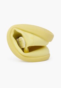Scarpa gialla con una tomaia in tessuto morbido e una suola in gomma flessibile. Il design è compatto con una cinghia ad anello per la regolazione.