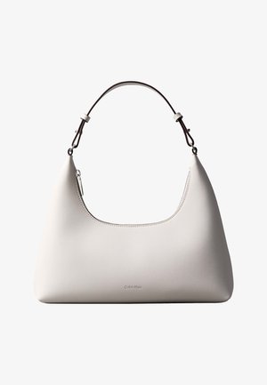 Τσάντα ώμου από δέρμα σε κρεμ απόχρωση Calvin Klein με καμπυλωτή κορυφή, ασημένιο φερμουάρ και σκουρό καφέ ρυθμιζόμενο λουρί.