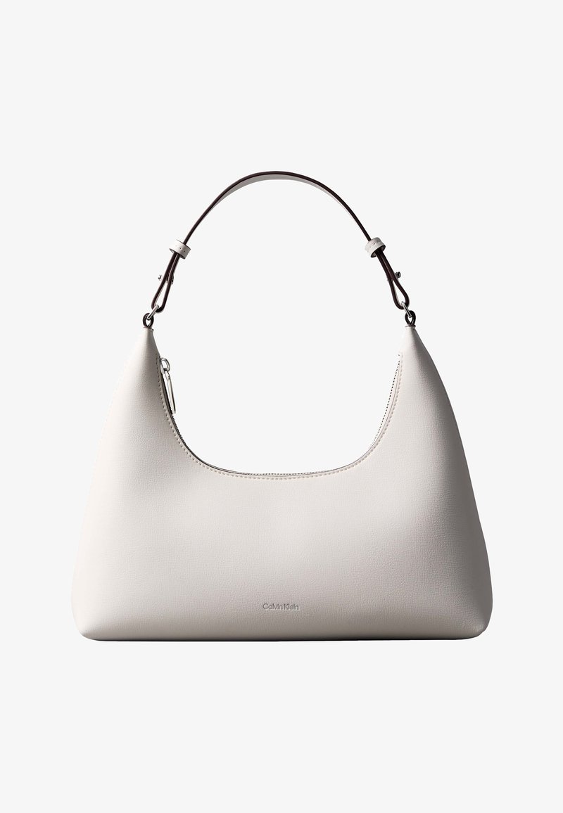 Τσάντα ώμου από δέρμα σε κρεμ απόχρωση Calvin Klein με καμπυλωτή κορυφή, ασημένιο φερμουάρ και σκουρό καφέ ρυθμιζόμενο λουρί.
