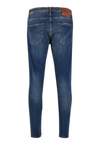 Jeans din denim albastru cu o croială slim, având o etichetă din piele maro la talie și două buzunare spate. Fading subtil pe întreaga țesătură.