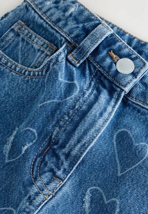 Shorts en denim de couleur bleu moyen, avec un motif en forme de cœur, des accents déchirés, un bouton en argent et une ceinture cousue.