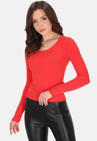 Rode geribbelde lange mouwen top met een ronde hals, gecombineerd met zwarte aansluitende leggings, die een gestructureerd materiaal en een slim-fit ontwerp tonen.