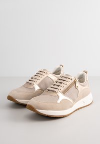 Sneaker beige realizzati in rete e suede, con un davanti lacciato, un accento in zip dorata e una suola in gomma con fondo marrone testurizzato.