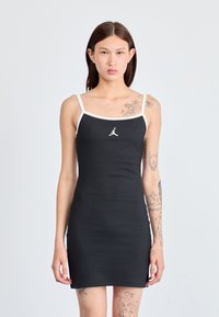 Zwarte bodycon jurk met witte banden en een logo op de borst. Glad materiaal, getailleerde vorm, knielang, met een minimalistisch ontwerp.
