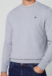 Grå sweatshirt lavet af bomuldsblanding med rund halsudskæring, lange ærmer, ribstrikkede manchetter og et lille navy-logo på brystet.