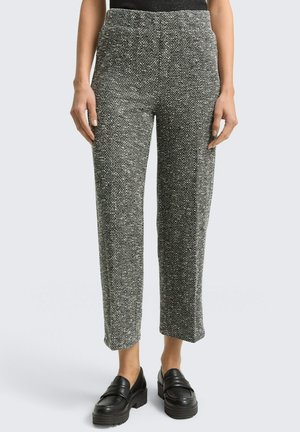 Graue Hosen mit Fischgrätenmuster, lockerer Passform, elastischem Bund und geradem Bein, kombiniert mit schwarzen Plateau-Loafers.