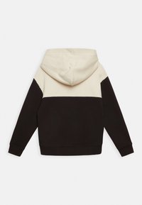 Felpa con cappuccio caratterizzata da un design a blocchi di colore con sezioni crema, marrone scuro e nero. Realizzata in cotone, ha una texture morbida.