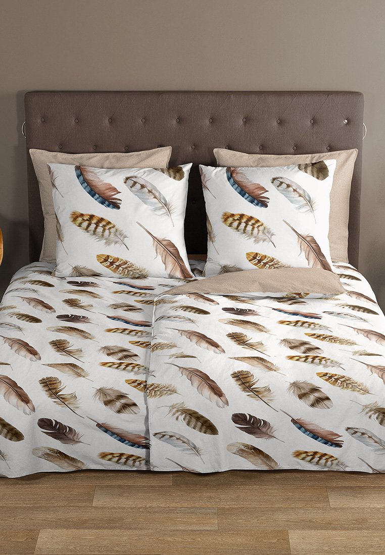 Doppelbett mit braunem gepolstertem Kopfteil, beigen Kissen und weißer Bettwäsche mit verschiedenen braunen und blauen Feder-Mustern.