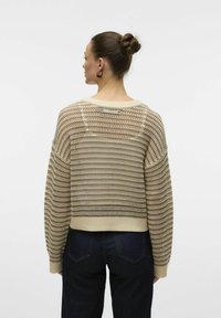 Beige textuur gebreide trui met een losse pasvorm, voorzien van een ruime hals en drop shoulders. Ribbelmatige onderkant en accenten in een horizontaal patroon.