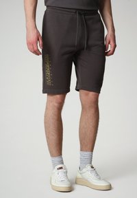 Shorts in cotone grigio scuro con vita regolabile tramite cordino, con un logo dorato stampato sulla gamba sinistra e orli risvoltati.