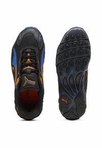 Zapatillas deportivas negras y azules con un acento naranja. Parte superior de malla, suela texturizada con patrones de agarre y un logo en el lateral.