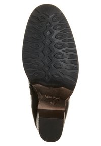 Suela de zapato de goma negra con un patrón texturizado que presenta formas ovaladas y diamantes; el nombre de la marca y la talla están grabados y son visibles cerca del talón.