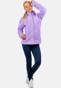 Veste en polaire violet avec fermeture éclair intégrale, col haut et manches longues. Tissu texturé et doux avec un logo sur la poitrine gauche. Silhouette ajustée.