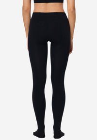Leggings neri a lunghezza intera realizzati in un materiale liscio e elasticizzato. Design a vita alta con retro senza cuciture e senza hardware visibile.
