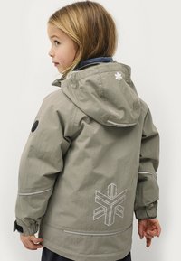 Khaki waterdichte jas met capuchon, voorzien van een wit logo op de rug, reflecterende accenten en elastische manchetten voor aanpassingsmogelijkheden.