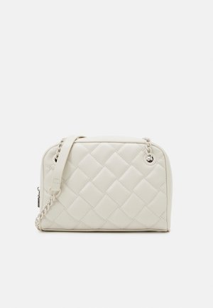 Borsa trapuntata color crema con tracolla a catena, dotata di chiusura con zip e superficie liscia e texturizzata. Forma rettangolare compatta.