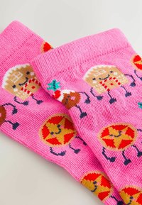 Pink socks featuring a repeated pattern of cartoon gingerbread men, Christmas cookies, and pizza slices. Made of knitted fabric.