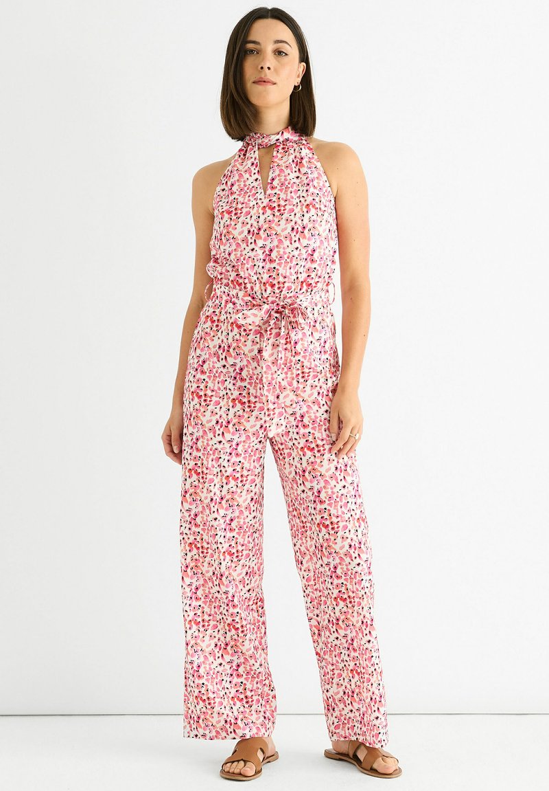 Halter-neck jumpsuit with a colorful floral pattern in shades of pink, red, and purple. Made of lightweight fabric, features a belted waist.