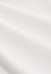 White fabric with a smooth texture, showcasing subtle weave details and folded layers. Even color distribution without patterns or accents.