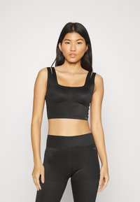 Sort cropped sports bra med firkantet halsudskæring og smalle stropper. Struktureret stof med en tætsiddende pasform. Matchende højtaljede sorte leggings.